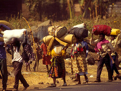 A stream of Rwandan refugees, carrying all their possession, walk into Goma after a civil war erupted in their country, Rwanda, 1994