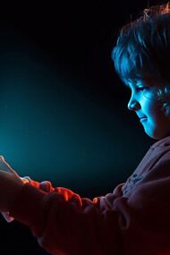 A boy appears frustrated while vlogging with a tablet, capturing the emotional impact of technology on children and the challenges posed by digital distractions
