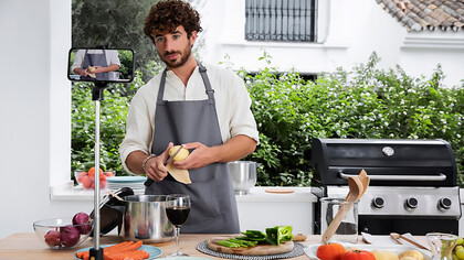 A male vlogger, live-streaming his cooking, exemplifies the impact of social media on culinary trends as a food influencer