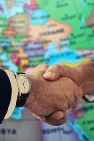 Two diplomats shaking hands in the spirit of global and dynamic diplomacy for the sake of sustainable peace
