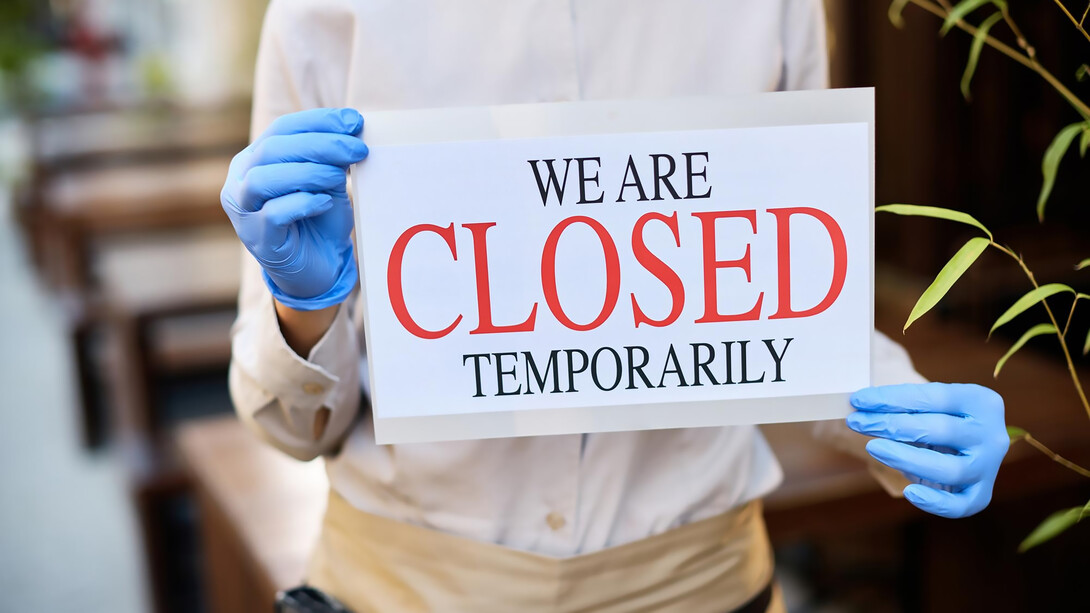 Closeup of owner closing a restaurant during coronavirus pandemic