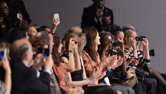 El público graba con sus cámaras y teléfonos móviles un desfile de moda
