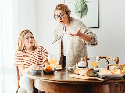 A mother speaking to her daughter with visible disappointment, reflecting the weight of unspoken expectations