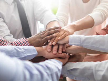 Equipo de trabajo uniendo las manos: el mayor compromiso siempre es contigo mismo