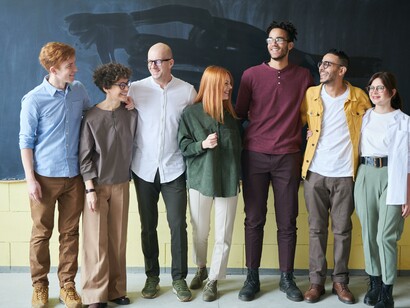A group of friend standing in front of a chalkboard. Multiculturalism can bring benefits to society 