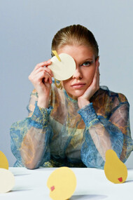 The model gazes into the lens, embodying the struggle between creativity and conformity in a rapidly changing world