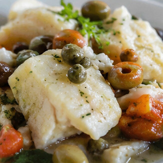 Stoccafisso all'Anconetana. Un capolavoro della cucina anconetana, dove lo stoccafisso viene cotto lentamente con pomodoro, patate, olive e aromi mediterranei