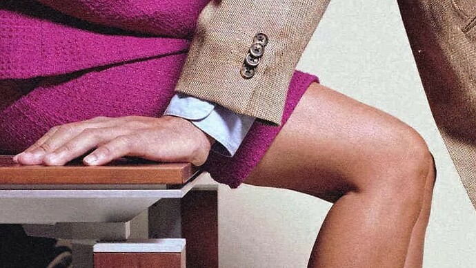 Un hombre inclinado sobre una mujer en su lugar de trabajo