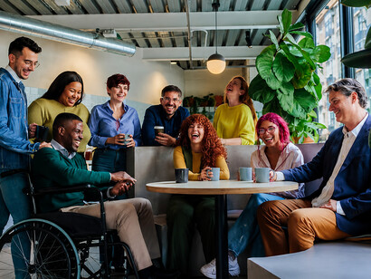 A multicultural business team gathers for a coffee break, fostering collaboration and inclusion in the workplace