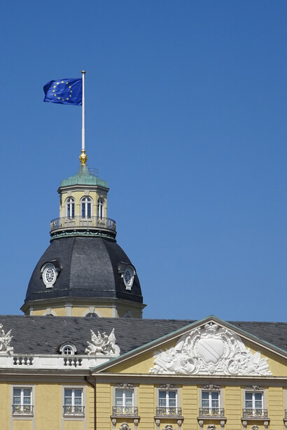 Segun Trump, los ciudadanos del Viejo Continente vivimos de gorra a costa del sacrificio del Nuevo Mundo, no es sino una proyección —otra más— del inquilino que tanta soberbia exuda por todas las paredes de la Casa Blanca. En conmemoración del Día de Europa, 9 de mayo 2025, la bandera europea ondea en la torre del Palacio de Karlsruhe, Alemania