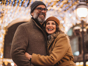 A mature couple sharing a joyful moment during a winter walk in the city