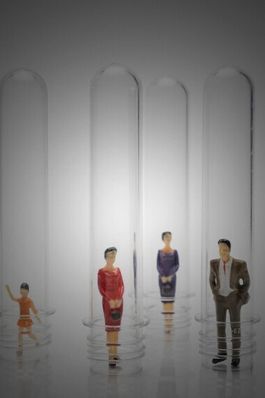 Individuals encapsulated in glass tubes, exploring themes of social identity and cultural diversity