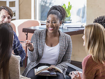 Guided by a charismatic leader, a diverse group actively participates in a enriching Bible study session.