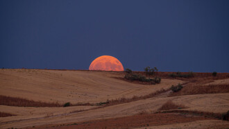 The moon rising behind the horizon bringing reflection and stillness