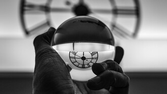 Orologio riflesso in una sfera. Tempo e immutabilità: una prospettiva esistenziale sull'inesorabile scorrere degli attimi