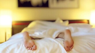 Person laying on their stomach asleep in bed