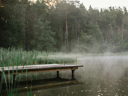 A wooden pier on a foggy, sleepy lake