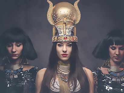 Portrait of a regal Egyptian queen adorned in an ancient pharaoh costume, accompanied by two concubines