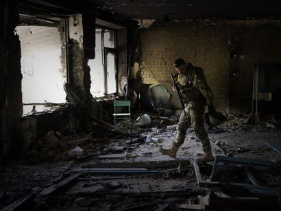 Un militar ucraniano inspecciona una escuela dañada durante una batalla entre las fuerzas rusas y ucranianas en la aldea de Vilkhivka, en las afueras de Kharkiv, en el este de Ucrania