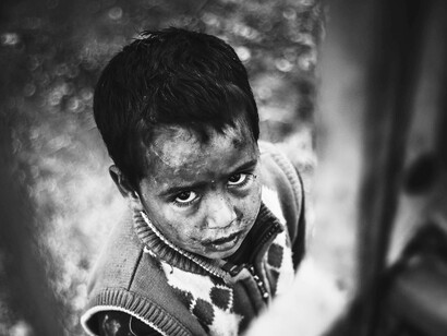 Primo piano di un bambino in difficoltà: "...capire come sia accaduto che, in varie parti del mondo, si siano progressivamente abbandonati o comunque ridotti i principi basilari del vivere comunitario"