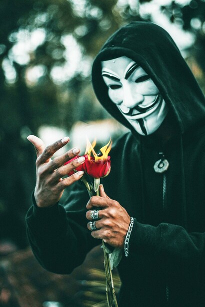 A masked figure with burning flowers