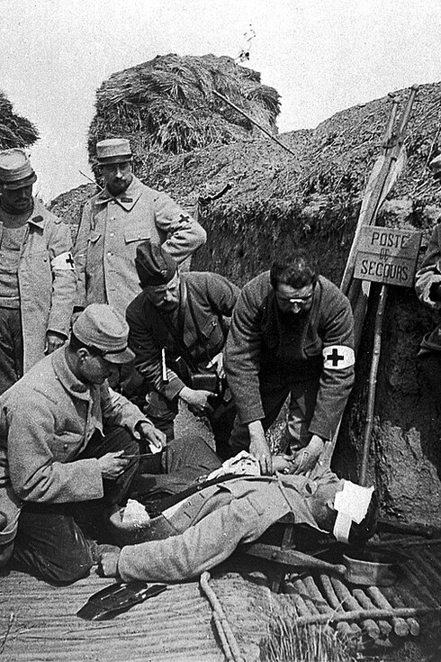 A regimental aid post in a World War I trench, where wounded soldiers received emergency medical treatment near the front lines. These makeshift medical stations played a vital role in caring for casualties amid the harsh conditions of trench warfare