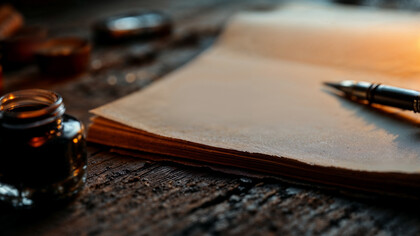 A pen and white pages, itching for a hand to bring it to life