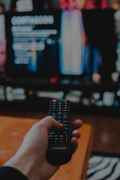 A person holding a black remote control