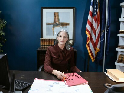 A woman seated confidently within a political office, representing the steady rise of female leadership in governance