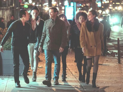 The energetic cast of the TV series “Sweetbitter” walking down the street at night