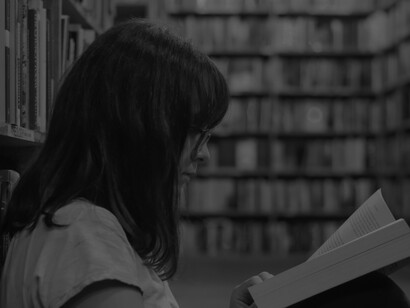 A student is reading one of her research books for knowledge to use in her thesis