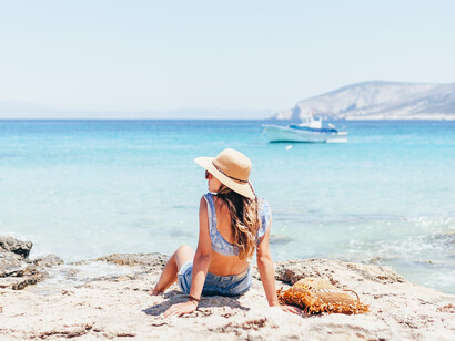 A woman sitting on the beach relaxing during her vacation