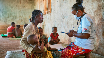 A Doctors Without Borders physician examines a mother and her child, providing vital healthcare in a conflict-affected region, demonstrating the critical role of non-state actors in addressing humanitarian needs