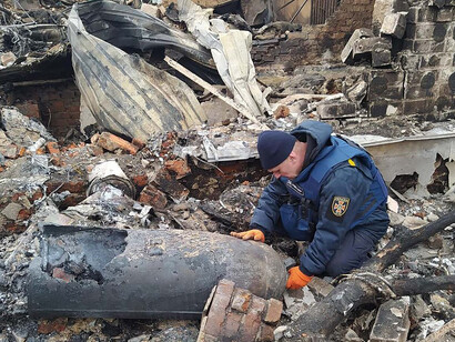 Personal de seguridad ucraniano inspecciona un proyectil ruso que destruyó un edificio residencial en Mykolaiv, en el sur de Ucrania