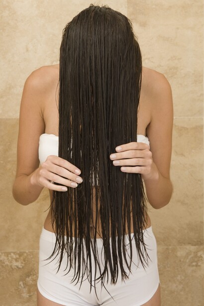 Una mujer limpiando y fortaleciendo su cabello