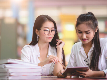 Two students immersed in quiet study, representing the persistent pursuit of knowledge even during uncertainty