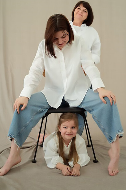 Three generations—grandmother, daughter, and granddaughter—pose together, their resemblance a testament to the enduring nature of humanity across the ages