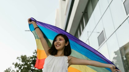 Asian homosexual couple embracing and hugging each other against a gray background
