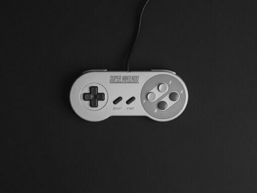 An original Super Nintendo Entertainment System set against a stark black backdrop, representing the enduring legacy of early home gaming