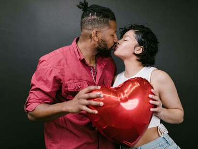 A couple holding up a heart balloon as they connect closer together in their relationship