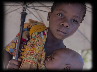 Menina leva bebe no colo segurando um guarda-chuva