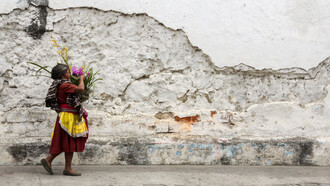 Mujer llevando un ramo de flores en la ciudad de Antigua, Guatemala