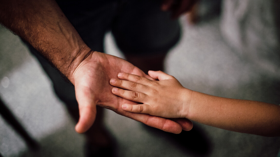Mãos de pai e filho se tocam em momento de comunhão fraterna
