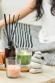 A woman assuming the yoga pose with her incense, candles, and other mediation-friendly trinkets
