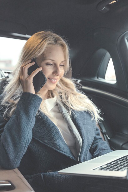 Mulher executiva atende ligação no carro