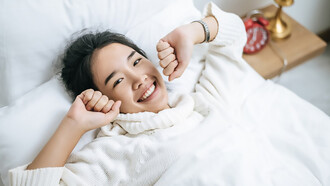 Women waking up happily in white shirts, showcasing improved sleep quality