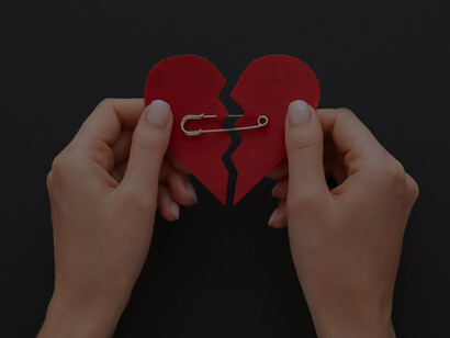 Top view of person holding broken heart put back together with safety pin