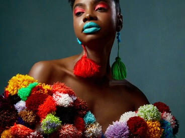 Uma mulher modelo vestindo uma roupa estilosa e cheia de cores. Cada look é uma narrativa visual que conecta estética, cultura e posicionamento
