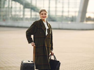 Mulher caminhando com suas malas durante uma viagem em clima frio. Para cérebros mais introvertidos, desacelerar e prestar atenção ao ambiente pode ser uma forma de transformar a viagem em experiência de presença e atenção plena