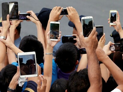 Grupo de jóvenes mostrando sus dispositivos móviles